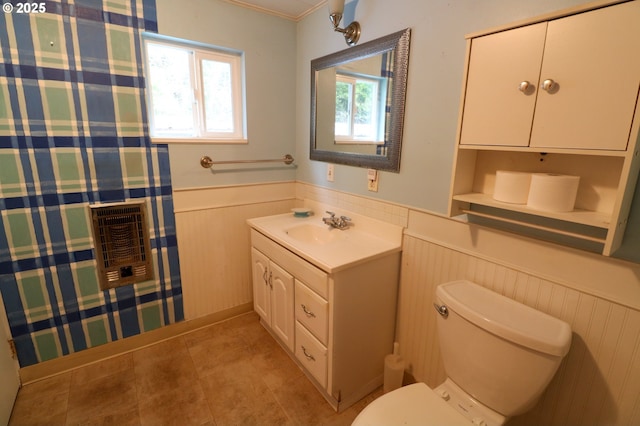 bathroom featuring tile patterned flooring, vanity, heating unit, and toilet