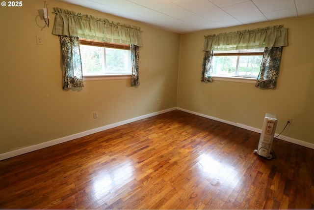 unfurnished room with hardwood / wood-style floors and a healthy amount of sunlight