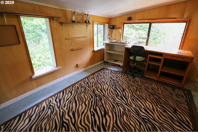 office area with vaulted ceiling and wooden walls