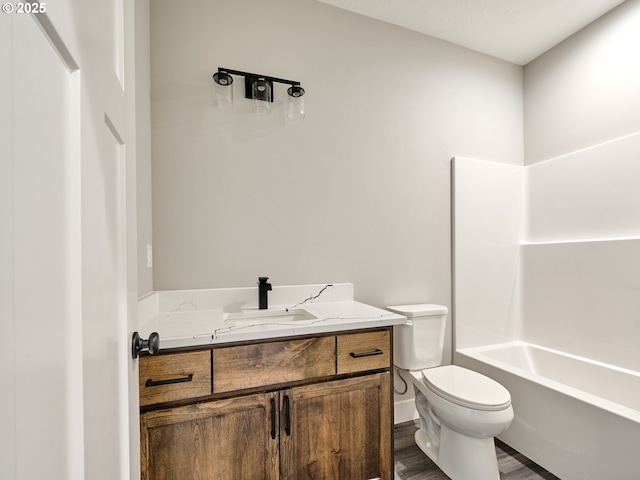 full bathroom featuring hardwood / wood-style flooring, vanity,  shower combination, and toilet