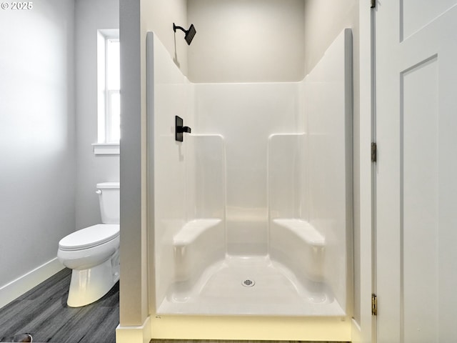 bathroom with a shower, hardwood / wood-style floors, and toilet