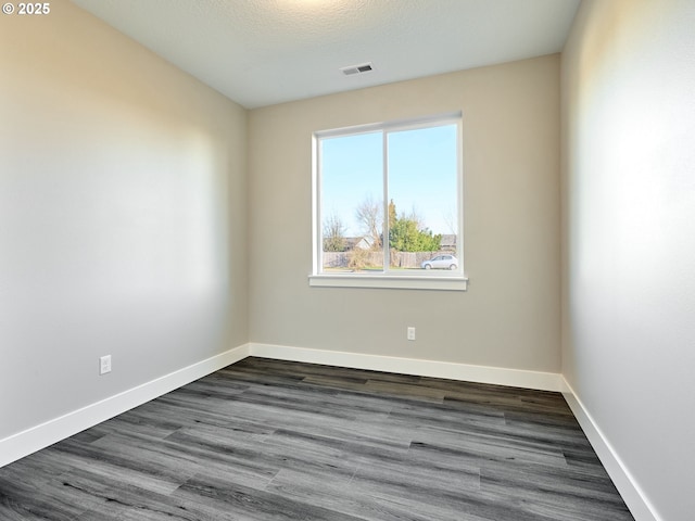 unfurnished room with dark wood-type flooring