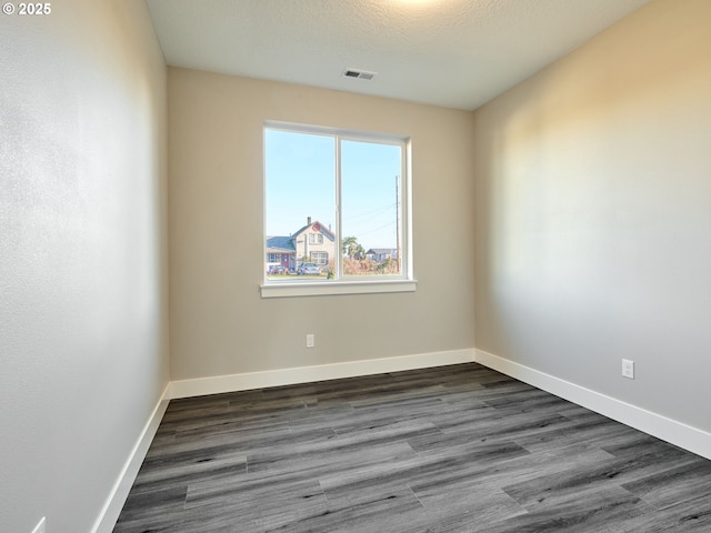 unfurnished room featuring a textured ceiling and dark wood-type flooring