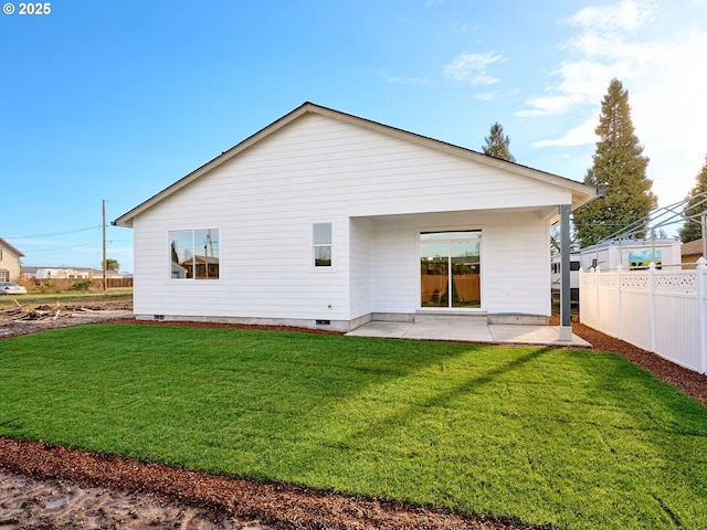 back of house with a yard and a patio