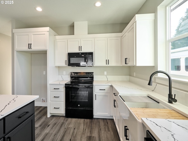 kitchen featuring black appliances, sink, dark hardwood / wood-style floors, light stone countertops, and white cabinetry