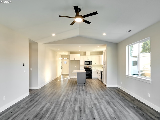 unfurnished living room with hardwood / wood-style flooring, vaulted ceiling, and ceiling fan