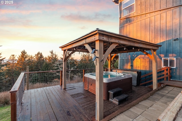 deck at dusk with a hot tub