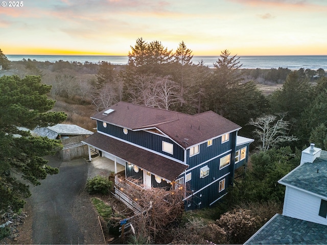 aerial view at dusk featuring a water view