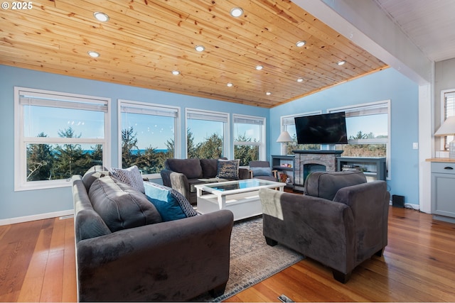 living room with lofted ceiling, wooden ceiling, light wood-type flooring, and a stone fireplace