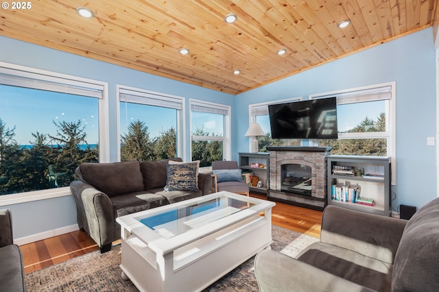 living room featuring wood-type flooring, lofted ceiling, wooden ceiling, and a stone fireplace