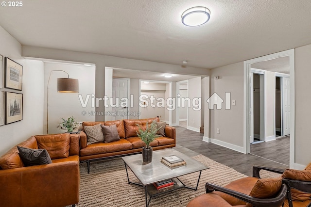 living room with dark wood-type flooring and a textured ceiling