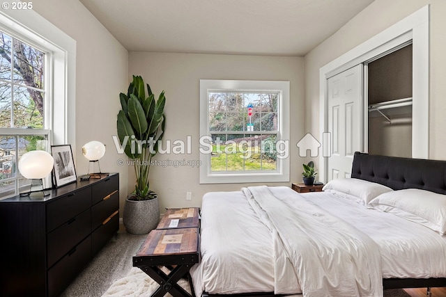 carpeted bedroom featuring multiple windows and a closet