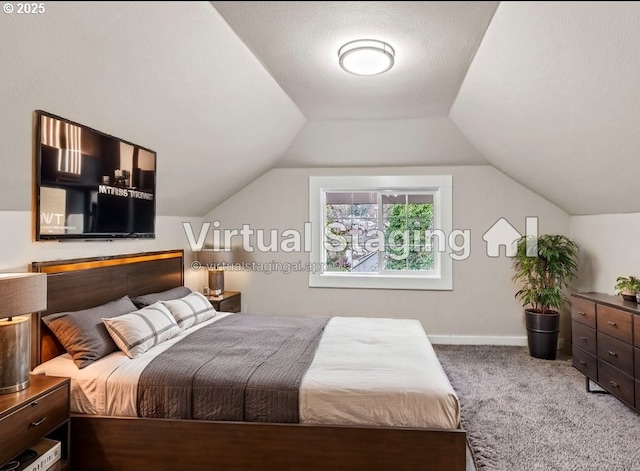 carpeted bedroom with lofted ceiling and a textured ceiling