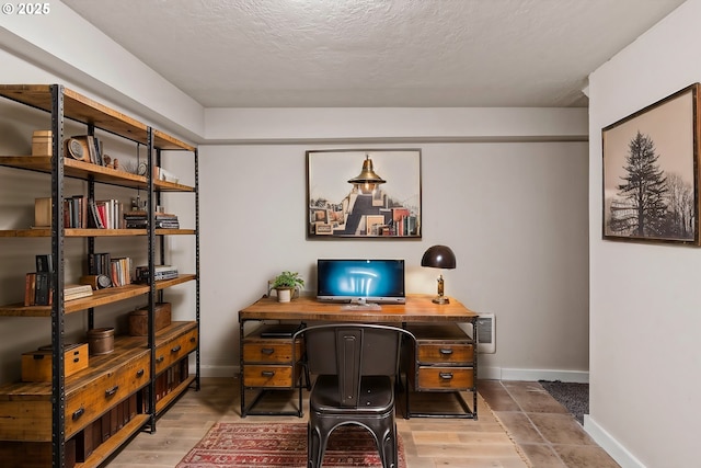 home office with hardwood / wood-style floors and a textured ceiling