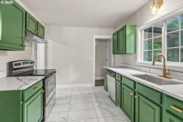 kitchen featuring sink, stainless steel appliances, green cabinetry, and light stone countertops