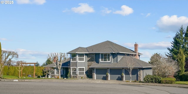 traditional home with driveway, a chimney, and an attached garage