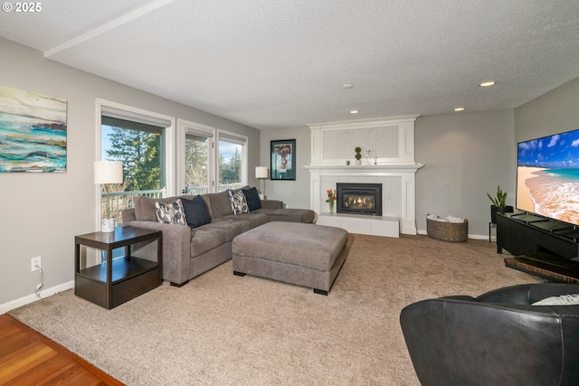 living area with a fireplace, baseboards, a textured ceiling, and recessed lighting