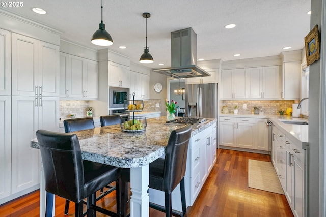 kitchen featuring a center island, island exhaust hood, stainless steel appliances, white cabinetry, and a sink