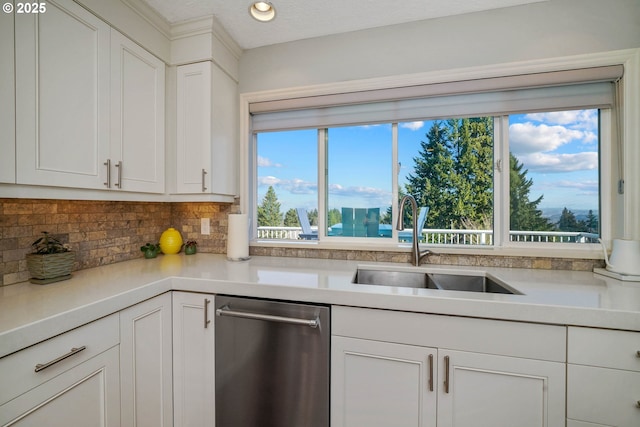 kitchen with a sink, white cabinets, light countertops, backsplash, and dishwasher