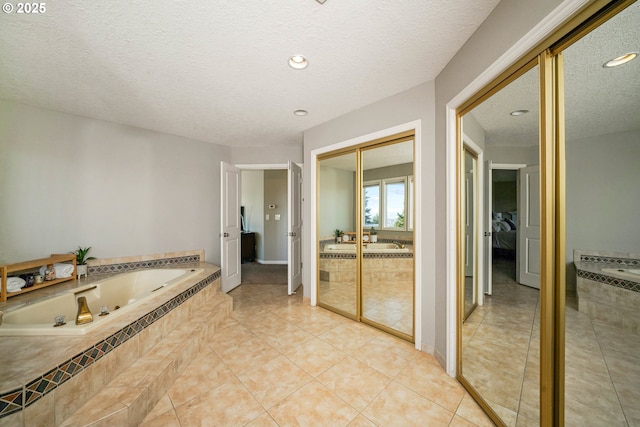 ensuite bathroom featuring recessed lighting, a textured ceiling, ensuite bath, a tub with jets, and tile patterned floors