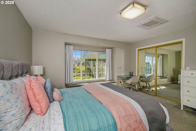 bedroom with a textured ceiling, a closet, and carpet flooring