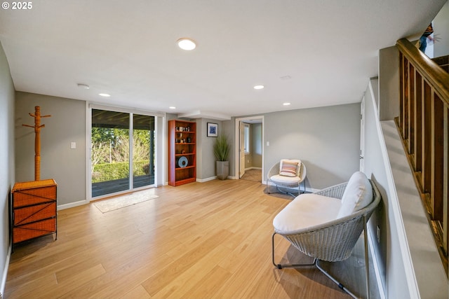 sitting room featuring stairs, baseboards, light wood-style flooring, and recessed lighting