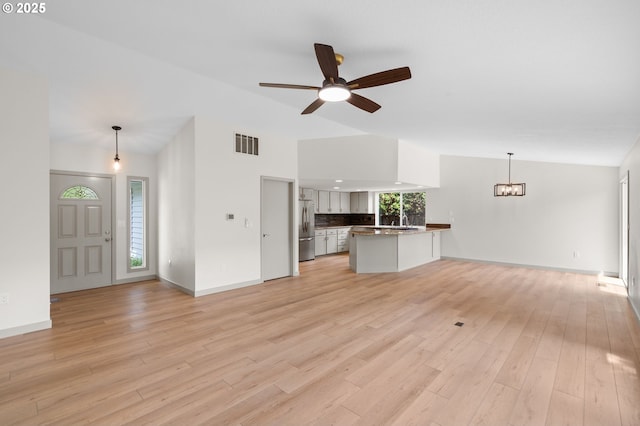 15080 SW 88th Ave, Portland, OR 97224 - unfurnished living room with vaulted ceiling, ceiling fan, light wood finished floors, and a chandelier