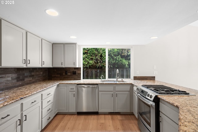15080 SW 88th Ave, Portland, OR 97224 - kitchen featuring appliances with stainless steel finishes, light wood-style flooring, decorative backsplash, recessed lighting, and light stone countertops