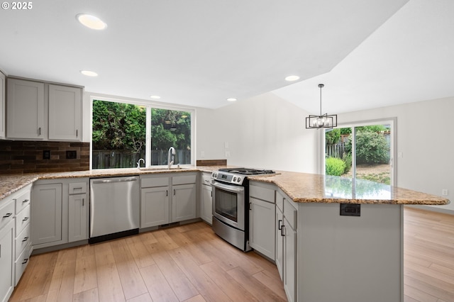 15080 SW 88th Ave, Portland, OR 97224 - kitchen featuring appliances with stainless steel finishes, a peninsula, gray cabinetry, light stone counters, and recessed lighting
