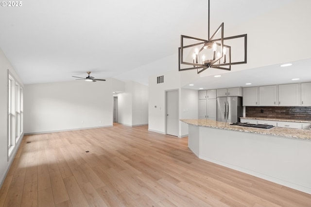 15080 SW 88th Ave, Portland, OR 97224 - kitchen featuring freestanding refrigerator, lofted ceiling, gas cooktop, decorative backsplash, and a chandelier