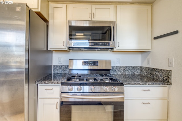 kitchen featuring appliances with stainless steel finishes and dark stone countertops