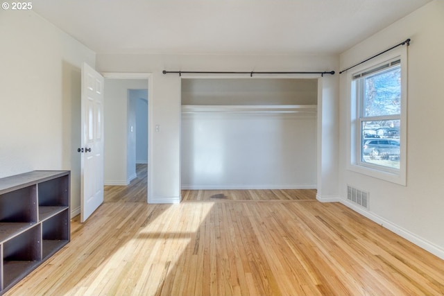 unfurnished bedroom featuring light hardwood / wood-style flooring and a closet