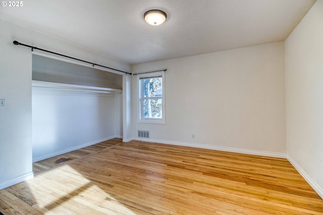 unfurnished bedroom featuring a closet and light wood-type flooring