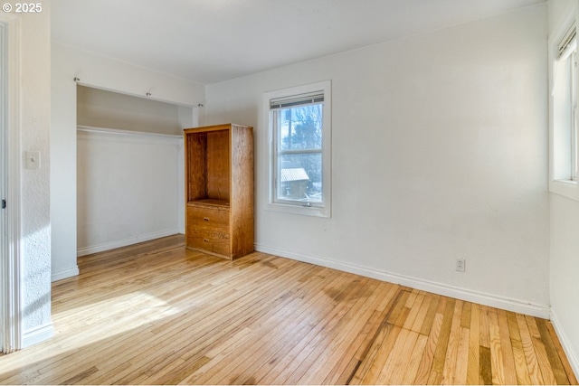 unfurnished bedroom featuring light hardwood / wood-style floors and a closet