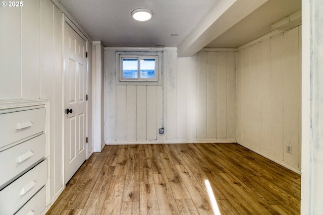 basement with hardwood / wood-style flooring and wood walls