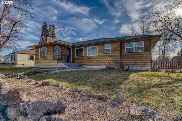 rear view of property featuring a lawn