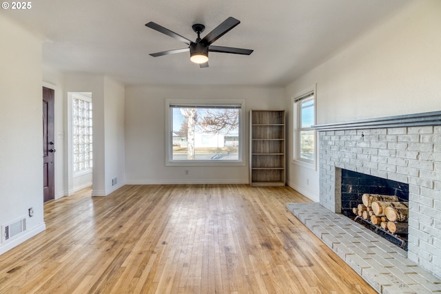 unfurnished living room with ceiling fan, a fireplace, and light hardwood / wood-style flooring