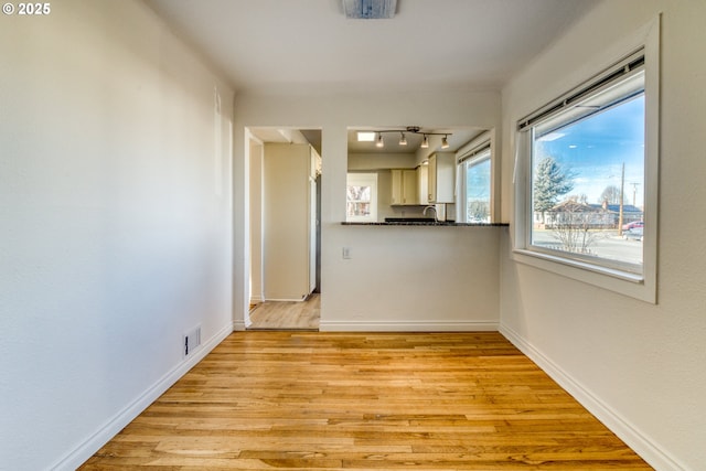 unfurnished room featuring sink and light hardwood / wood-style floors