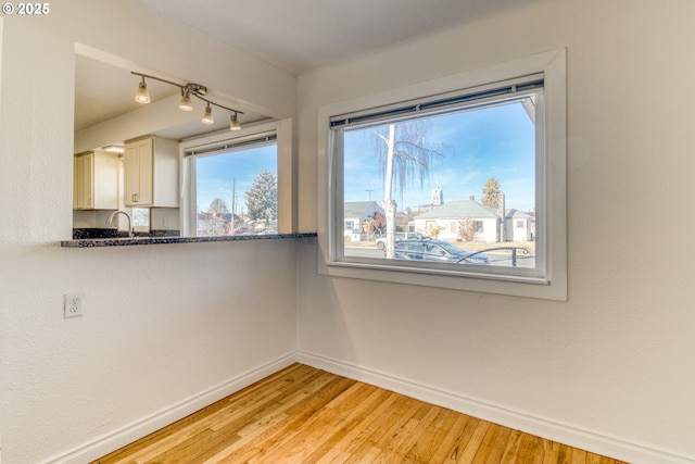 unfurnished dining area with sink and light hardwood / wood-style flooring