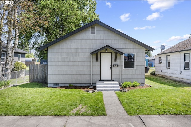 bungalow-style home featuring fence and a front lawn