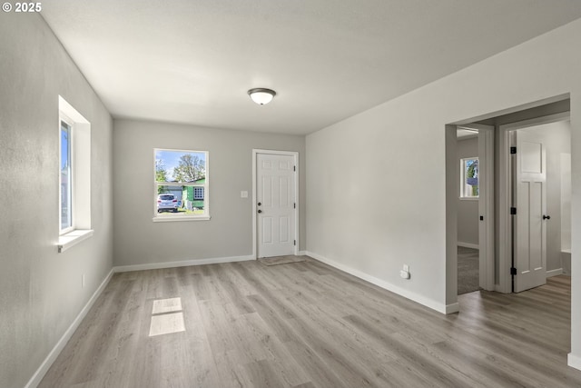 interior space with baseboards and light wood-type flooring