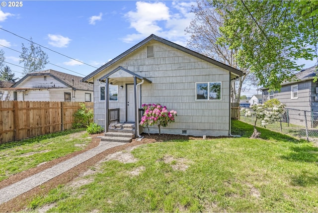 bungalow-style house with a fenced backyard, crawl space, and a front yard