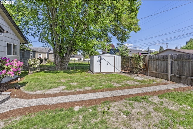 view of yard featuring a fenced backyard, a storage unit, and an outbuilding