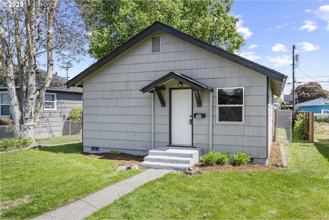 bungalow-style house with a front lawn, crawl space, and fence