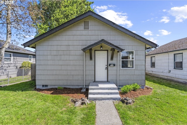 bungalow-style house featuring fence and a front lawn