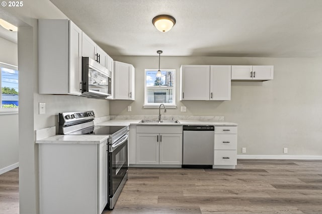 kitchen featuring a wealth of natural light, stainless steel appliances, light wood-style flooring, and a sink