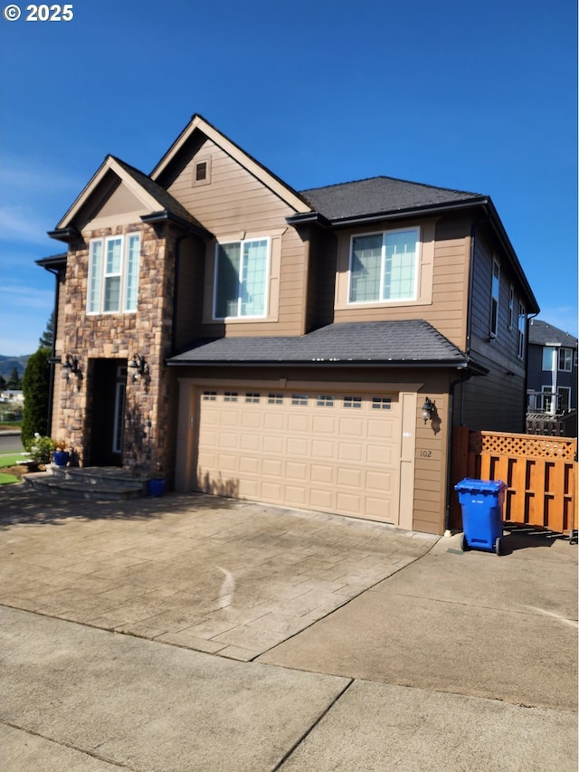 102 Sarah Bear Ln, Winston, OR 97496 - view of front of home with concrete driveway, stone siding, a shingled roof, an attached garage, and fence