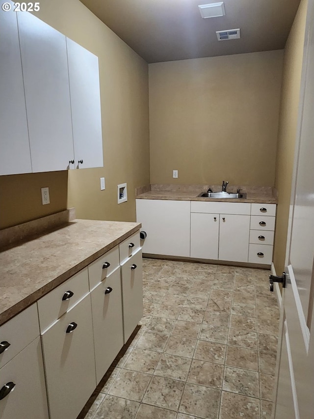 102 Sarah Bear Ln, Winston, OR 97496 - laundry area with a sink, cabinet space, stone finish flooring, visible vents, and washer hookup