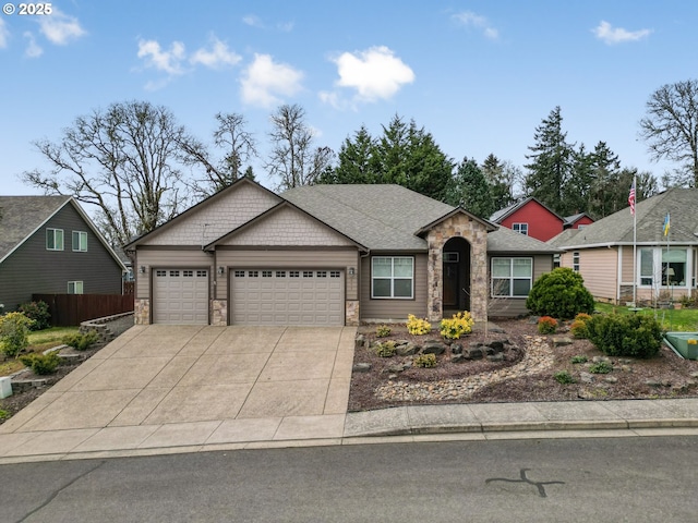 view of front of property with a garage, a shingled roof, concrete driveway, stone siding, and fence