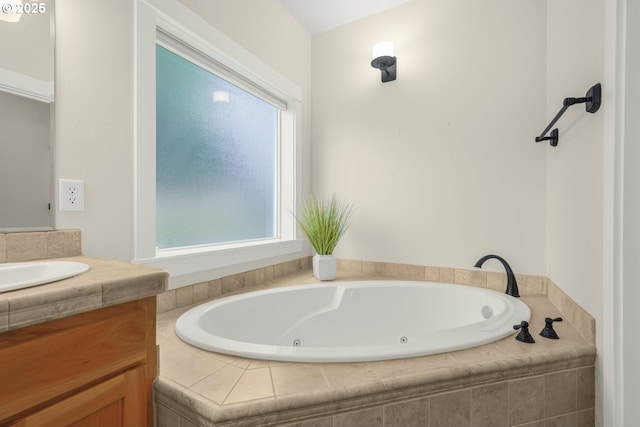 bathroom featuring a tub with jets and vanity